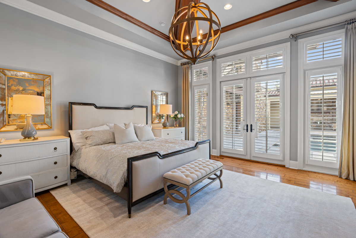 master bedroom with gold light fixture and wooden ceiling panels